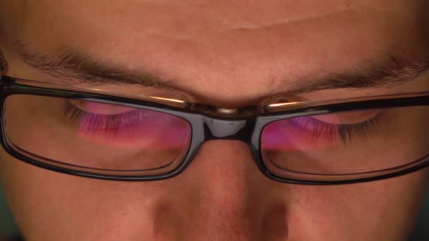 Mans okulary ciemne felgi odzwierciedlające komputer typu tablet w ciemności. 4k ekstremalnych bliska strzał — Wideo stockowe
