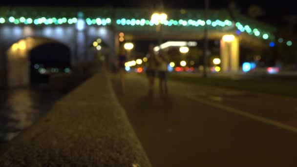 Menina corredor desfocado e pessoas andando em aterro urbano à noite. Clipe de bokeh 4K — Vídeo de Stock