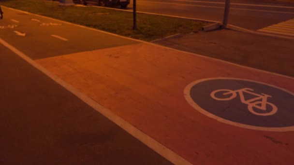 Ciclista y corredor que pasa por el carril bici urbano por la noche. Vídeo 4K — Vídeo de stock