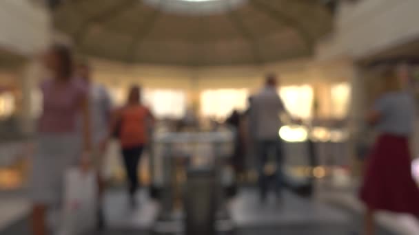 Gente borrosa en escaleras móviles en el moderno centro comercial. Clip bokeh de fondo 4K — Vídeos de Stock