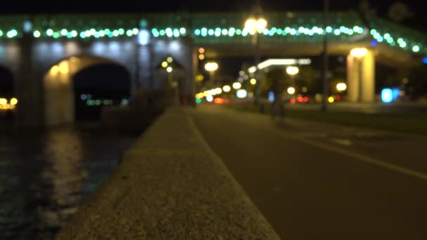 Cycliste flou sur un remblai urbain la nuit. Clip bokeh 4K — Video