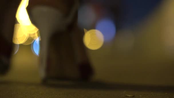 Θολή κορίτσι σε ψηλά τακούνια περπατώντας από την κάμερα τη νύχτα. Ρηχά εστίαση βίντεο 4k — Αρχείο Βίντεο