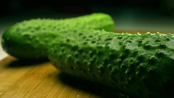 Zelené okurky na dřevěném prkénku postřiku vodou. Super slow motion výstřel — Stock video