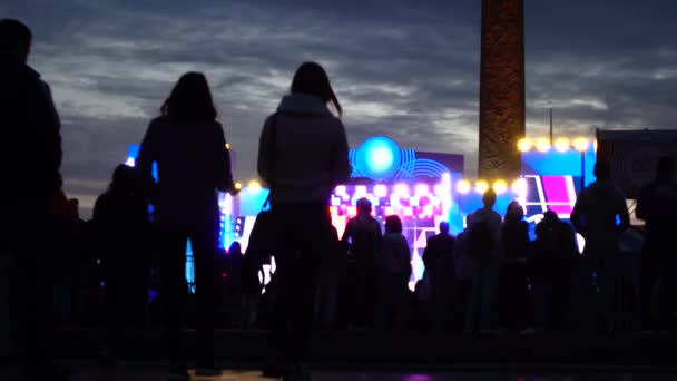 Les silhouettes des gens se dirigent vers le spectacle de nuit. Coup 4K — Video