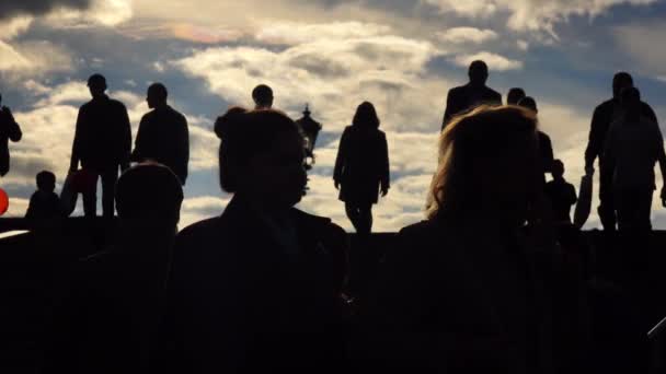 Silhouetten von Menschen, die oben und unten gegen den Himmel laufen. 4k-Schuss — Stockvideo