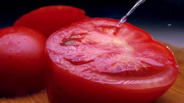 Espolvorear agua sobre tomate rojo cortado. Colores fríos. Super cámara lenta tiro — Vídeos de Stock