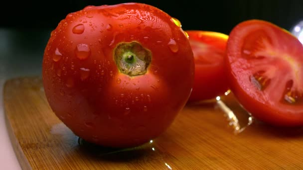 Hombre cortando tomate maduro sobre tabla de madera. 4K primer plano de vídeo — Vídeo de stock