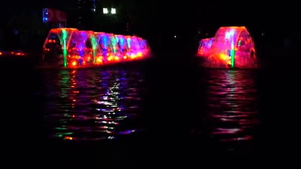 Fuentes multicolores iluminadas por led en la noche y ondulación de agua reflectante. Vídeo 4K — Vídeos de Stock