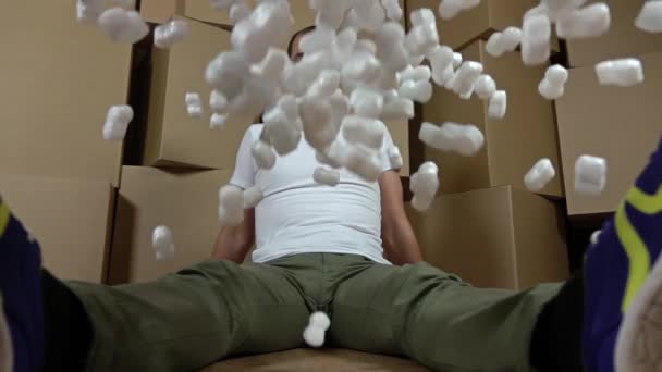 Koncepcje bezpieczeństwa i ubezpieczenia. Wylewanie miękkie kawałki styropianu na szczęśliwym człowiekiem. Opakowania odporne na uderzenia. Super slow motion video — Wideo stockowe