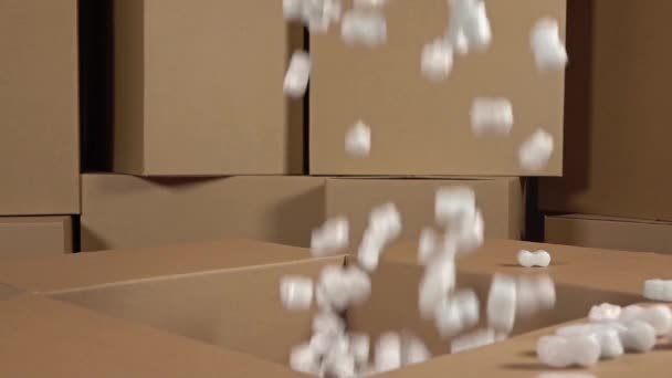 Giessen weiche Styroporstücke in großen Karton. stoßfestes Verpackungsmaterial. Sicherheits- und Versicherungskonzepte. Zeitlupenvideo — Stockvideo