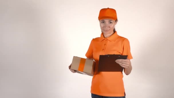 Mensajera en uniforme naranja sosteniendo una caja de cartón. 4K plano de estudio, aislado — Vídeos de Stock