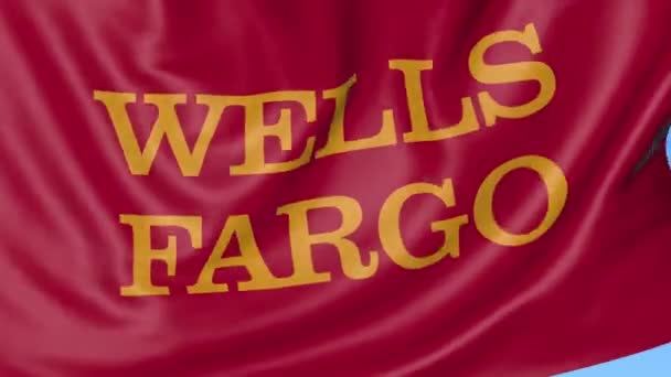 Tutup melambaikan bendera dengan logo Wells Fargo, lingkaran mulus, latar belakang biru. Animasi editorial. Profil 4K, alfa — Stok Video
