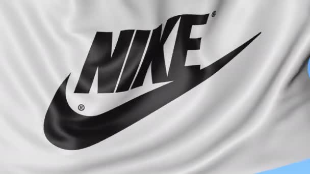 Primer plano de la bandera ondeante con inscripción y logotipo de Nike, lazo sin costuras, fondo azul. Animación editorial. 4K ProRes, alfa — Vídeos de Stock