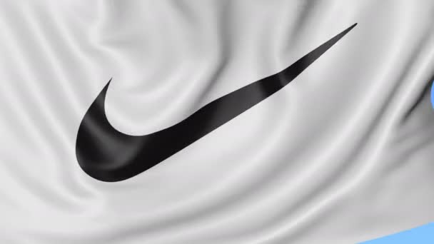 Primo piano della bandiera sventolante con logo Nike, Swoosh. loop senza cuciture, sfondo blu. Animazione editoriale. 4K ProRes, alfa — Video Stock