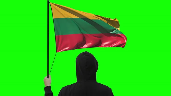 Ismeretlen férfi tartja lengő zászló Litvánia, elszigetelt zöld alapon — Stock Fotó