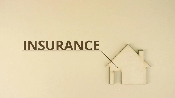 Ícone de casa de papelão com texto INSURANCE na mesa — Fotografia de Stock