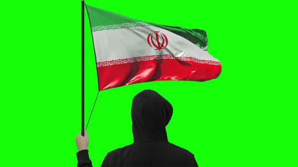 Неизвестный держит флаг Ирана, изолированный на зеленом фоне — стоковое фото