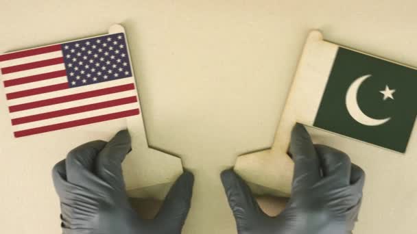 Флаги США и Пакистана из переработанной бумаги на картонном столе — стоковое видео