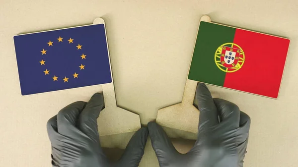 Držení vlajek Evropské unie a Portugalska z recyklovaného papíru na kartonovém stole — Stock fotografie