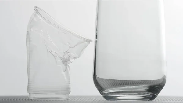 Taza de plástico plegable y un vaso sobre fondo claro. Sostenibilidad del concepto de plásticos —  Fotos de Stock