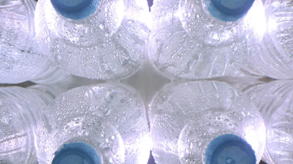 Vista dall'alto verso il basso di bottiglie di plastica fredda umida di acqua minerale — Foto Stock