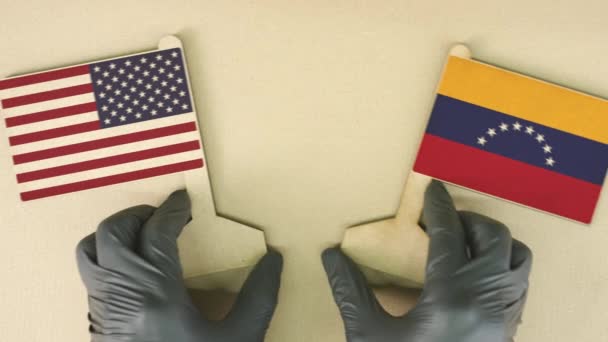 Держа на столе флаги США и Венесуэлы из картона — стоковое видео
