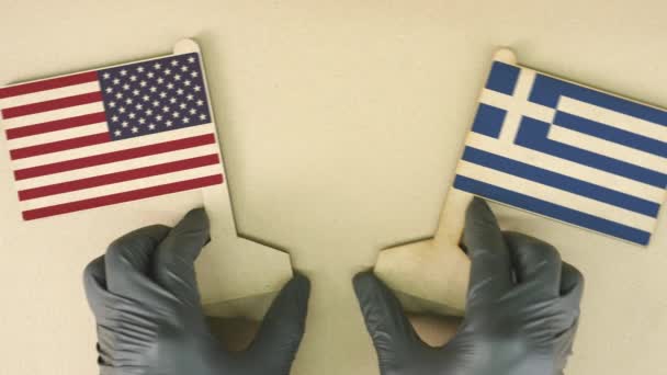 Flaggen der USA und Griechenlands aus Altpapier auf dem Papptisch — Stockvideo
