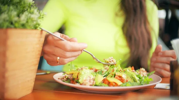 Belle femme mange salade végétalienne dans un café — Photo