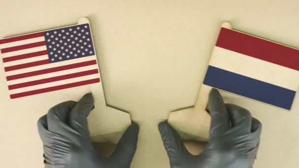 Flaggen der USA und der Niederlande aus Altpapier auf dem Papptisch — Stockvideo