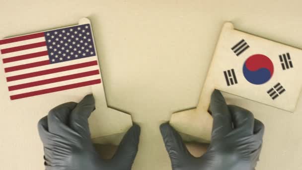 Flaggen der USA und Koreas aus Altpapier auf dem Papptisch — Stockvideo