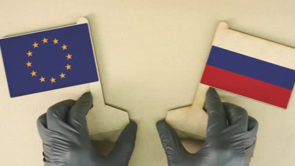 Vlaggen van de Europese Unie en Rusland van gerecycled papier op de kartonnen tafel — Stockvideo