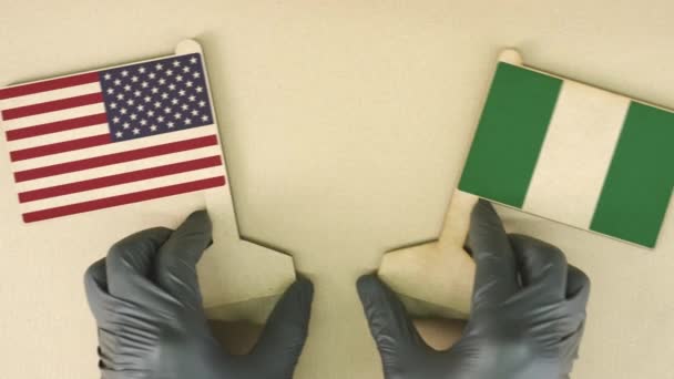 Флаги США и Нигерии из переработанной бумаги на картонном столе — стоковое видео