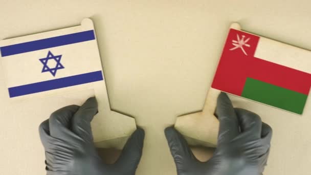 Banderas de Israel y Omán hechas de papel reciclado en la mesa de cartón, vista de arriba hacia abajo — Vídeo de stock