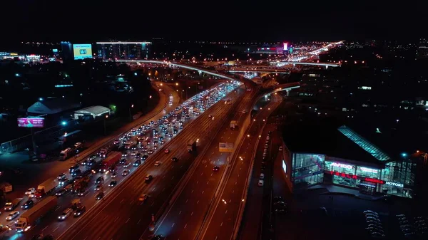 MOSCOW, RÚSSIA - 29 de outubro de 2020. Vista aérea de Tesla concessionária de automóveis e engarrafamento no intercâmbio rodovia à noite — Fotografia de Stock