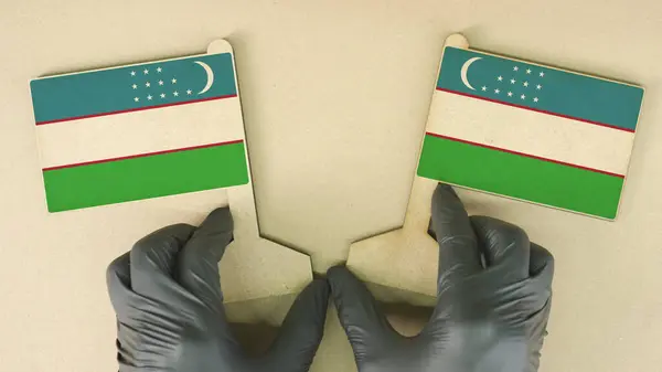 Banderas de Uzbekistán hechas de papel reciclado en la mesa de cartón —  Fotos de Stock