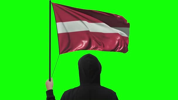 Latvias flagg og ukjent mann iført svart, alfamatte – stockvideo