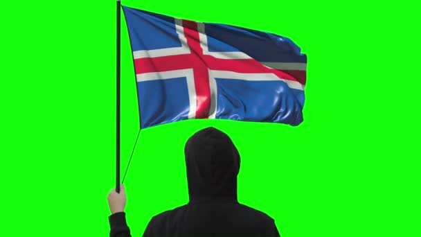 Ondeando la bandera de Islandia y el hombre desconocido vistiendo negro, alfa mate — Vídeos de Stock