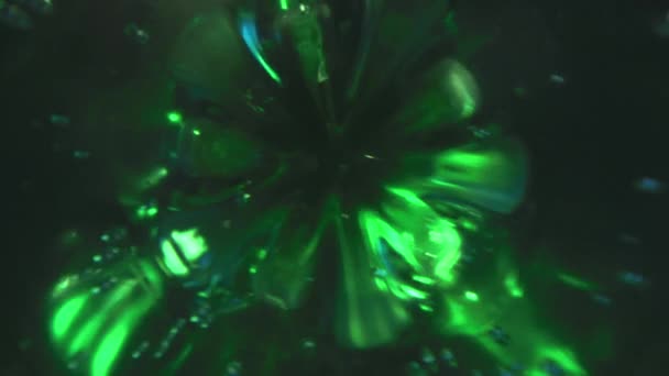 在一个绿色的矿泉水塑料瓶上盖上一个盖子，探头镜头像娃娃一样被射中 — 图库视频影像