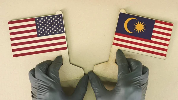 Flags of the USA and Malaysia made of recycled paper on the cardboard table — Stock Photo, Image