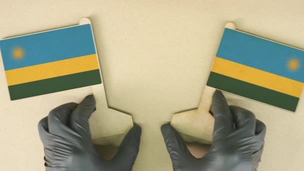 Banderas de Ruanda hechas de papel reciclado en la mesa de cartón — Vídeo de stock