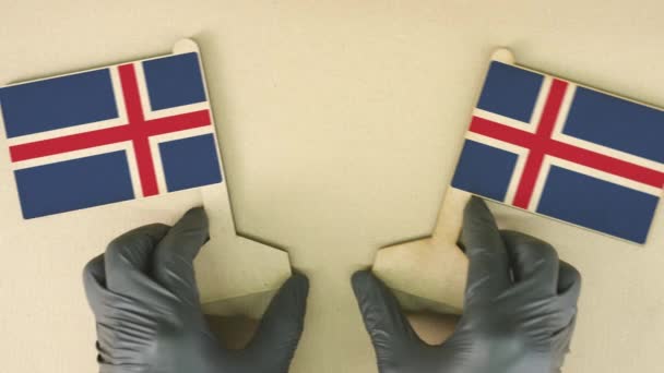Флаги Исландии из переработанной бумаги на картонном столе — стоковое видео