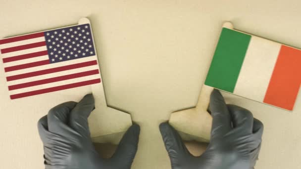Drapeaux des États-Unis et d'Irlande en papier recyclé sur la table en carton, vue du haut vers le bas — Video