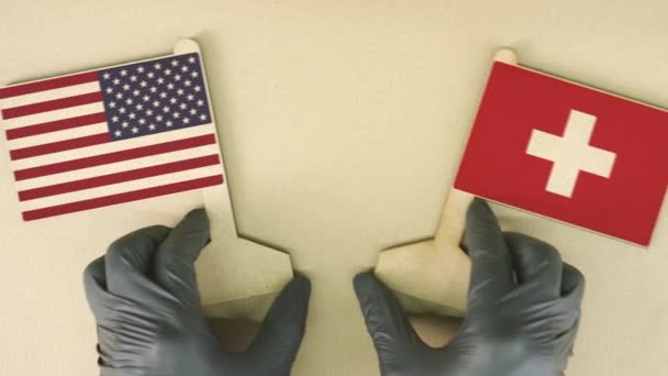 Флаги США и Швейцарии из переработанной бумаги на картонном столе — стоковое видео