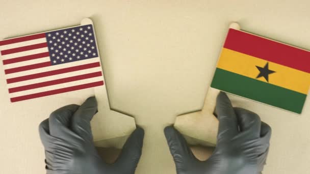 Bandeiras dos EUA e Gana feitas de papel reciclado na mesa de papelão, vista de cima para baixo — Vídeo de Stock