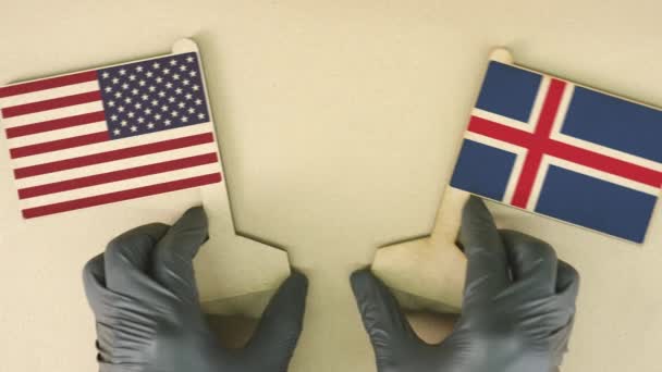 Флаги США и Исландии из переработанной бумаги на картонном столе — стоковое видео