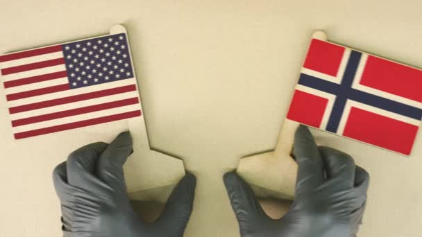 Drapeaux des États-Unis et de la Norvège en papier recyclé sur la table en carton, vue du haut vers le bas — Video