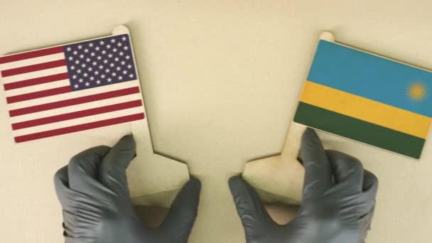 Vlajky USA a Rwandy vyrobené z recyklovaného papíru na kartonovém stole — Stock video