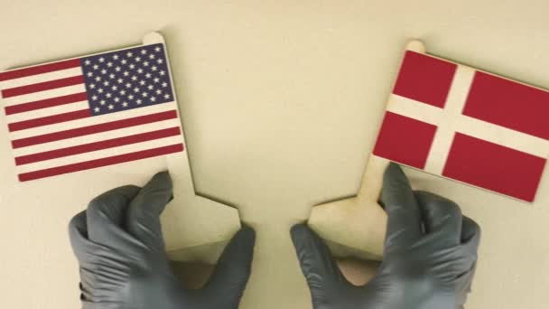Держащие флаги США и Дании из переработанной бумаги на картонном столе, вид сверху вниз — стоковое видео