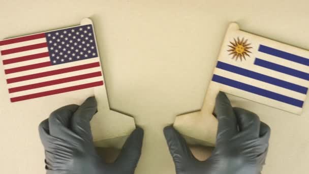 Bandeiras dos EUA e Uruguai feitas de papel reciclado na mesa de papelão — Vídeo de Stock
