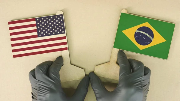 Флаги США и Бразилии из переработанной бумаги на картонном столе — стоковое фото